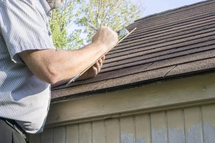 A man inspecting a house roof